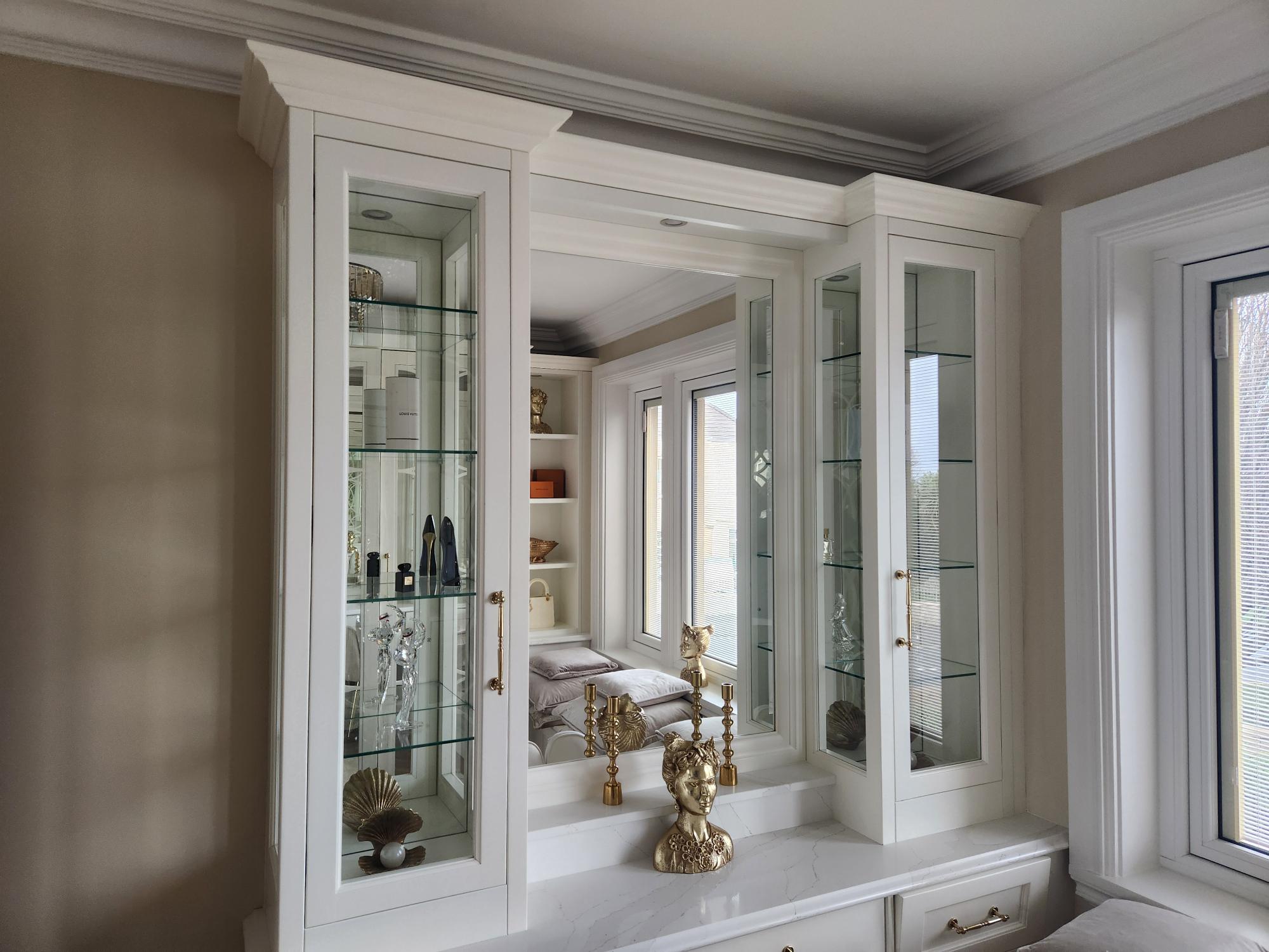 White fitted display cabinets with glass doors and pass-through opening