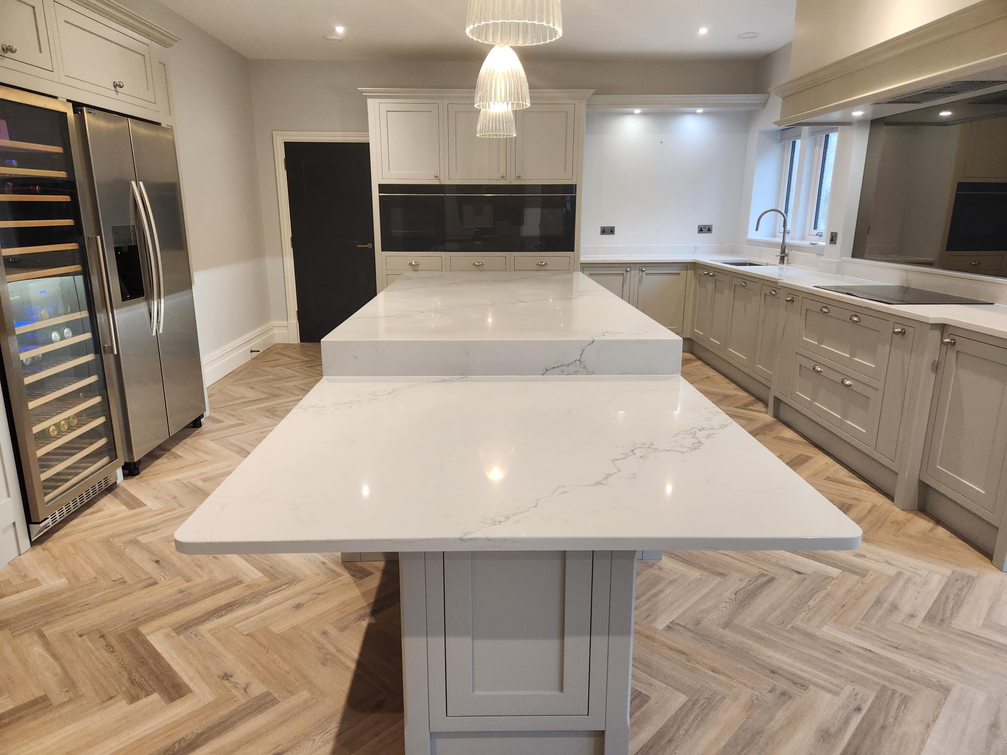 Kitchen with marble breakfast bar and pendant lights