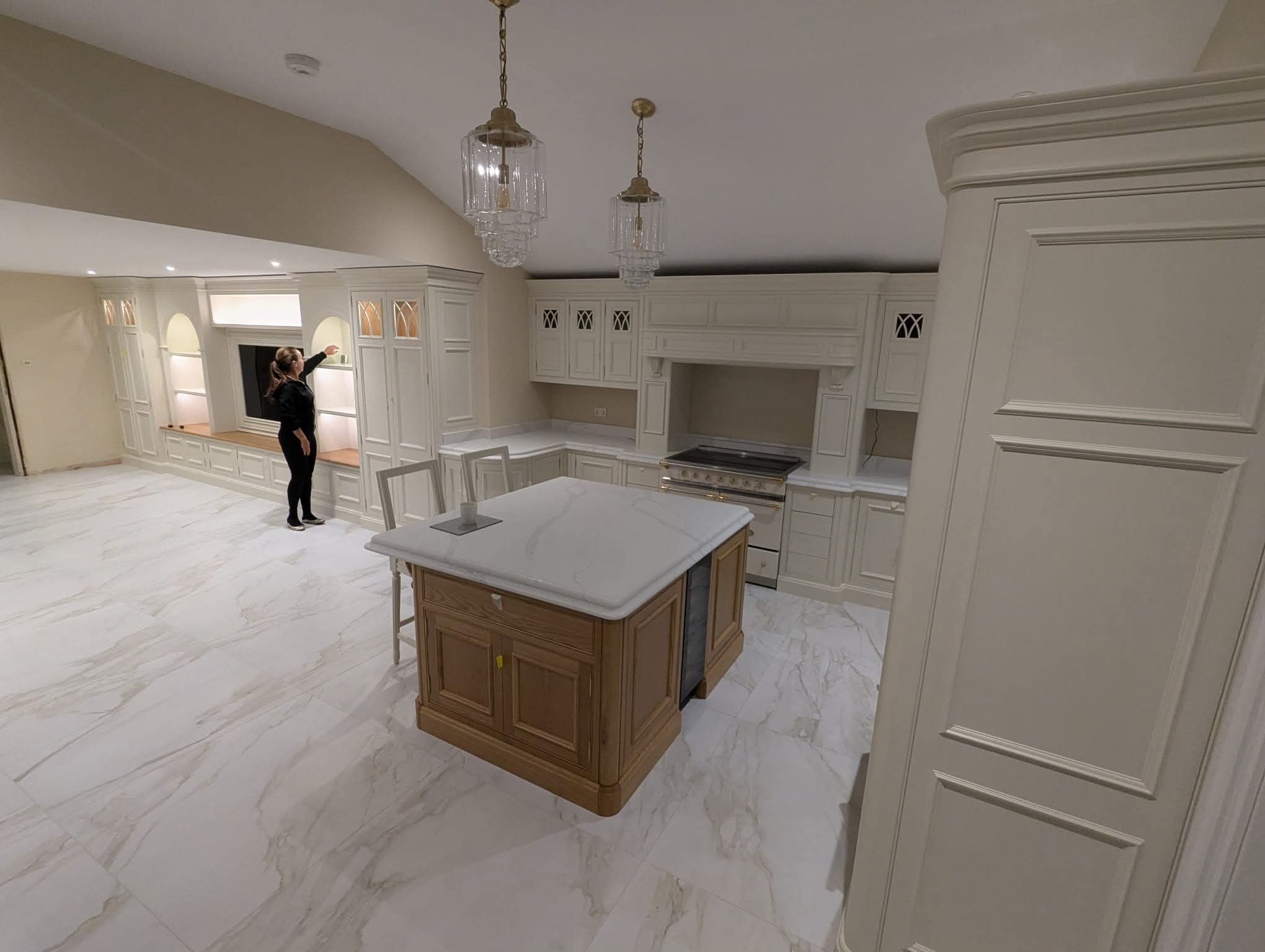 Completed luxury kitchen with crystal pendants, oak island and marble floor
