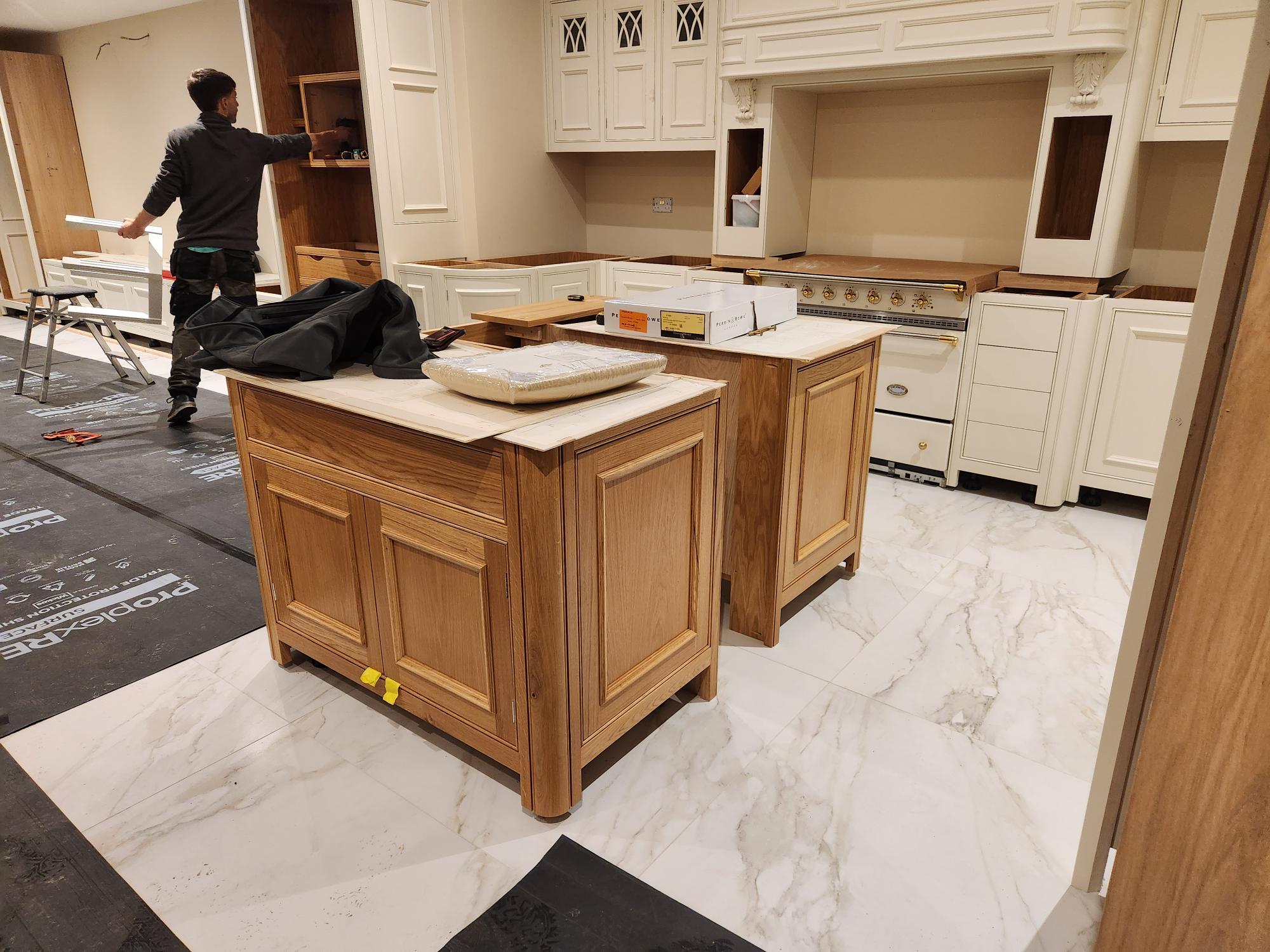 Solid oak kitchen island installation with cream perimeter units