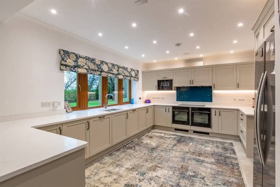 Modern shaker kitchen with blue glass splashback and quartz worktops