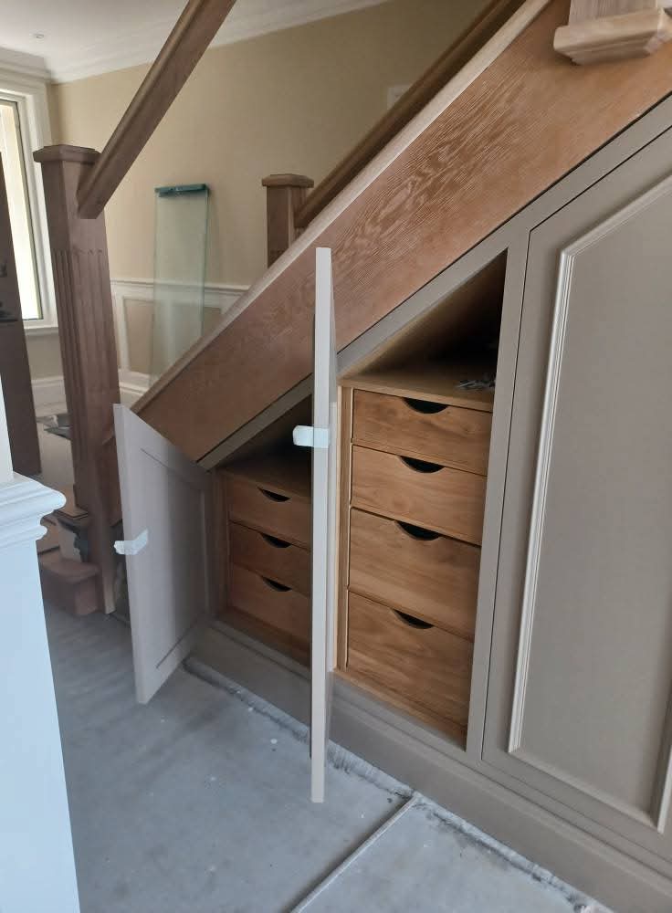 Under-stairs storage with oak drawers and painted cupboard doors